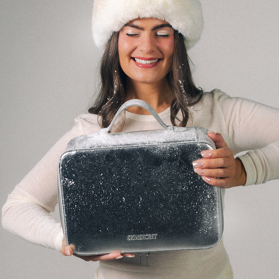 Modell holder SkinSecret Julekalender 2026 med snø på lokket