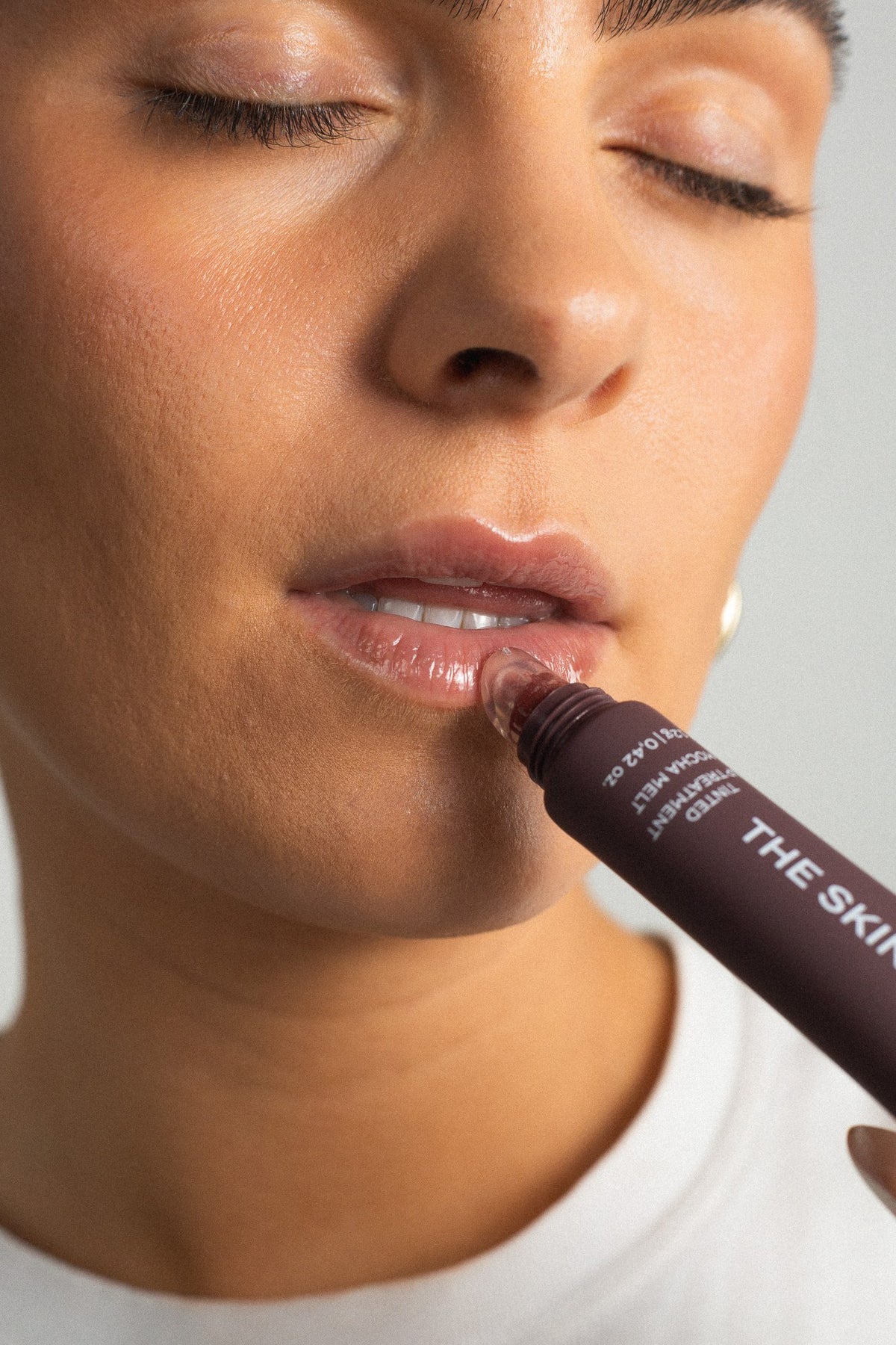 Modell påfører Tinted Lip Treatment Mocha Melt
